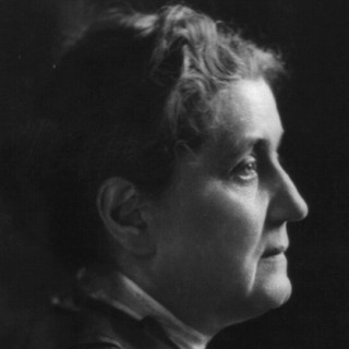A grayscale photo portrait of Jane Addams looking directly to the right into the distance. Her hair is braided up onto her head in a practical style. Her facial expression looks exhausted and a little worried. Photo Credit: Moffett, 1914. Source: Library of Congress
